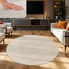 A modern living room with a round rug, sofa, and TV. Produktbild-Vorschau
