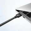A black USB-A to USB-A cable is plugged into a silver laptop. Anteprima dell’immagine prodotto