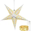 A white star-shaped lantern with yellow star and moon cutouts, hanging from a string. A coil of LED string lights and a battery pack are shown in the foreground. Podgląd zdjęcia produktu