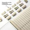 A collection of beige-colored pleating accessories and a partially visible pleated blind on a white background. Produktbild-Vorschau