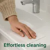 A person's hand is cleaning a white sink with a wipe. Anteprima dell’immagine prodotto
