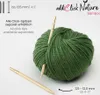 A ball of green yarn with knitting needles inserted, with product information and branding in the background. Produktbild-Vorschau