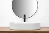 A white oval countertop sink with a black faucet is shown in a bathroom setting. Náhľad obrázku produktu