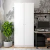 A white two-door wardrobe is shown in a room with a desk and computer setup. Náhled obrázku produktu