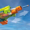 Close-up of a toy gun with a dart being fired, against a blue sky background with clouds. Produktbild-Vorschau
