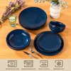 A set of blue ceramic dishes arranged on a wooden table, with a glass of water and some dried flowers. Náhled obrázku produktu
