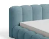 A close-up view of a blue upholstered bed frame with a mattress. Voir les images du produit