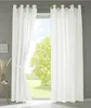 A window with white curtains, showing a green tree and blue sky outside. Produktbild-Vorschau