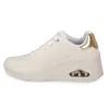 A side view of a white Skechers sneaker with gold accents. Voir les images du produit