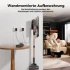 A woman is playing with a white dog in a living room, while a vacuum cleaner is mounted on the wall in the foreground. Produktbild-Vorschau