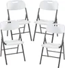 Four white folding chairs with black metal frames, arranged in a loose formation on a white background. Podgląd zdjęcia produktu
