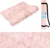 A collage of images showing a pink yoga mat with a leaf pattern, both rolled up in a carrying bag and unrolled. Podgląd zdjęcia produktu