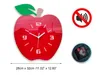 A red apple-shaped clock with a green leaf and a beige stem, shown with a no-sound symbol and the clock mechanism. Produktbild-Vorschau