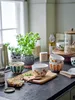 A kitchen counter with bowls, bread, and a plant. Produktbild-Vorschau