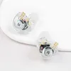 Two transparent in-ear monitor headphones are placed on a white surface. Produktbild-Vorschau
