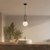 A modern pendant light hangs above a sink in a bathroom. Náhled obrázku produktu
