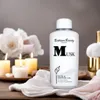 A bottle of Bettina Barty Musk Bath & Shower Gel is displayed on a wooden surface with lit candles and white flowers in the background. Anteprima dell’immagine prodotto
