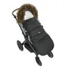 A black winter footmuff with a fur-lined hood is placed on a stroller. Podgląd zdjęcia produktu