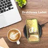 A flat lay of a desk scene with a laptop, coffee, and a smartphone charging on a wireless charger. Produktbild-Vorschau