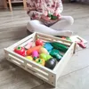 A child is playing with a wooden toy food set. Náhled obrázku produktu