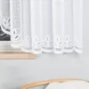 A close-up view of a white lace curtain with a leaf pattern along the bottom edge. Anteprima dell’immagine prodotto