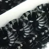 A close-up view of multiple black metal candle holders with fluted edges, arranged in a box. Produktbild-Vorschau