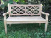 A wooden bench sits on grass in front of some foliage. Produktbild-Vorschau