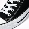 A close-up view of a black Converse All Star sneaker, focusing on the lacing and sole. Voir les images du produit