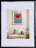 A framed picture of a red poppy hangs on a wall above a sofa. Produktbild-Vorschau