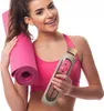 A woman is holding a yoga mat and a water bottle. Produktbild-Vorschau