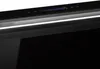 A close-up view of the top control panel of a black appliance, likely a range hood or oven, with a silver accent strip and blue LED indicators. Produktbild-Vorschau