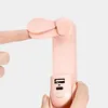 A close-up of a pink handheld fan being held by a finger, showing the USB ports. Anteprima dell’immagine prodotto