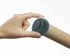 A hand is holding a gray measuring device over a wooden rolling pin with markings. Produktbild-Vorschau