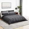 A bedroom scene with a bed dressed in dark gray and gray striped bedding. Produktbild-Vorschau