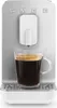 A close-up shot of a SMEG coffee machine dispensing coffee into a glass mug. Voir les images du produit