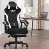 A black and white gaming chair is shown in a room with a desk and laptop in the background. Anteprima dell’immagine prodotto