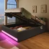 A bed with its storage compartment open, revealing stored items and illuminated by LED lights. Produktbild-Vorschau