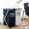 A person is putting a white shirt into a two-compartment laundry basket. Anteprima dell’immagine prodotto