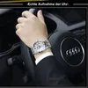 A person's hand wearing a watch is on the steering wheel of a car. Produktbild-Vorschau