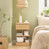 A bedroom scene with a wooden nightstand next to a bed. Produktbild-Vorschau
