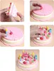 A collage of images showing the assembly and decoration of a toy birthday cake. Anteprima dell’immagine prodotto
