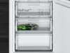 Close-up view of the interior of a refrigerator or freezer, showing multiple transparent drawers. One drawer contains a green item in a plastic bag. Produktbild-Vorschau