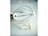 A close-up, slightly angled view of a metal whisk attachment for a stand mixer, with some white residue, likely meringue or whipped cream, clinging to its wires and sitting on a light-colored surface. Náhled obrázku produktu