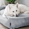 A white dog lying on a gray dog bed. Produktbild-Vorschau