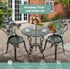 A garden bistro set with a round table and two chairs, set up on a gravel patio in front of a brick house. Produktbild-Vorschau