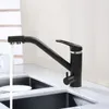 A black kitchen faucet with water running into a sink. Produktbild-Vorschau