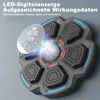 A close-up, angled view of a black, circular electronic device with multiple hexagonal pads and illuminated blue and red accents. A transparent overlay displays digital readouts and buttons. Produktbild-Vorschau