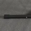 A close-up view of a black metal stand for a punching bag, resting on a textured gray surface. Podgląd zdjęcia produktu