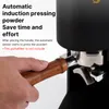 A hand is holding a coffee tamper, about to place it into a coffee machine. Produktbild-Vorschau