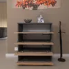 A modern shoe cabinet with four flip-down doors, placed in a hallway next to an umbrella stand. Produktbild-Vorschau